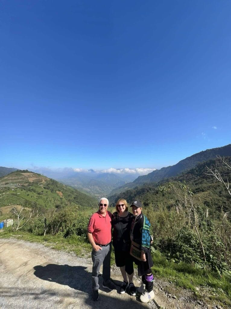 Trekking group posing on a scenic mountain trail in Sa Pa under a clear blue sky