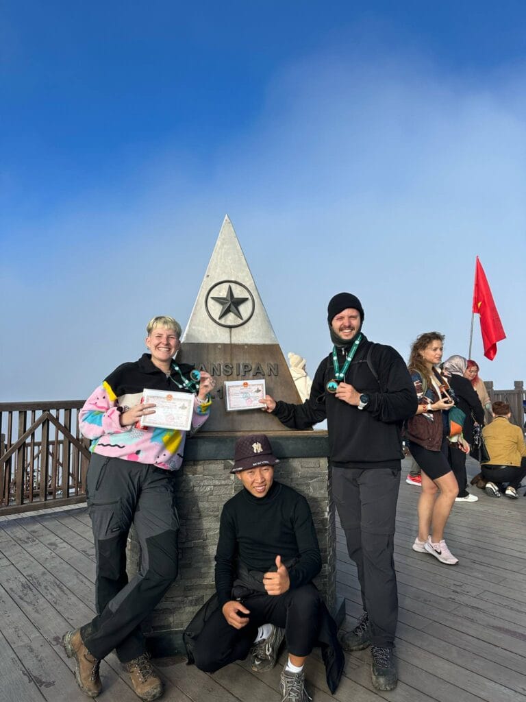 Trekking group at the summit of Fansipan with local guides in Sapa