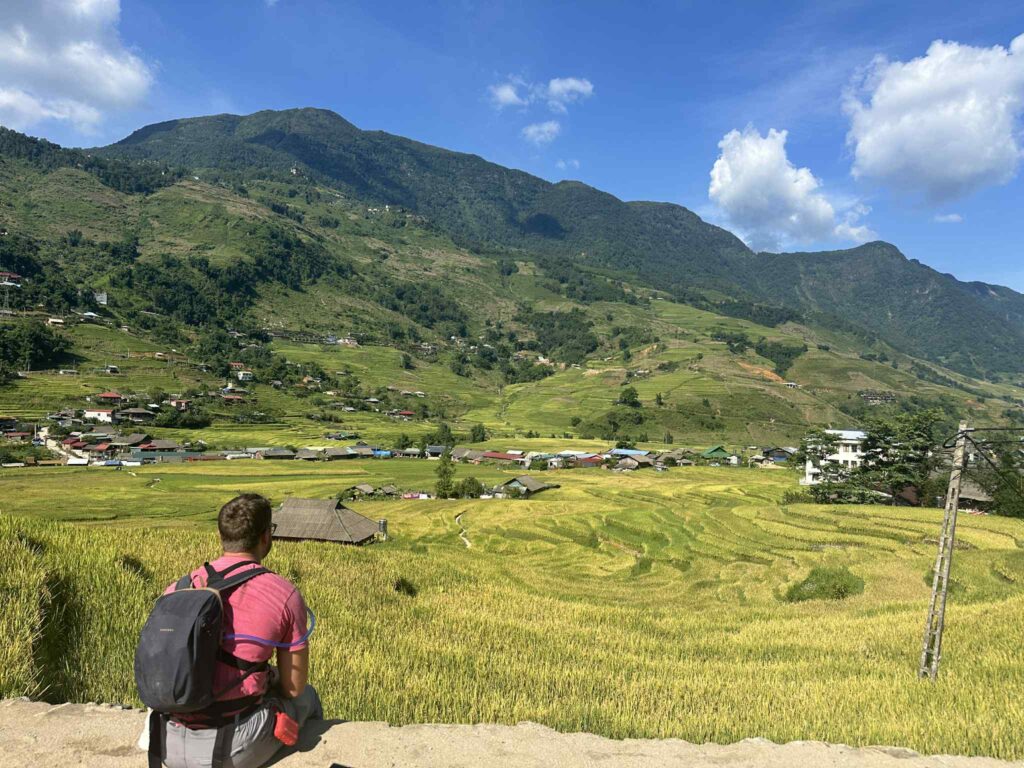 Traveler admiring Sapa rice terraces and mountain landscape