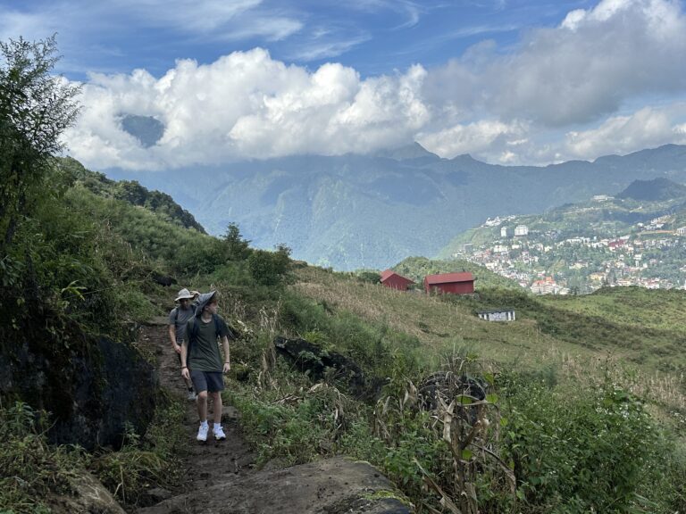 Trekking uphill in Sapa’s Muong Hoa Valley with panoramic mountain views