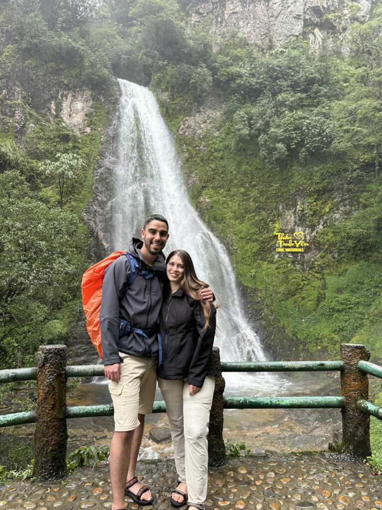Couple visiting Silver Waterfall, famous trekking spot in Sapa Caption: A romantic stop at Silver Waterfall